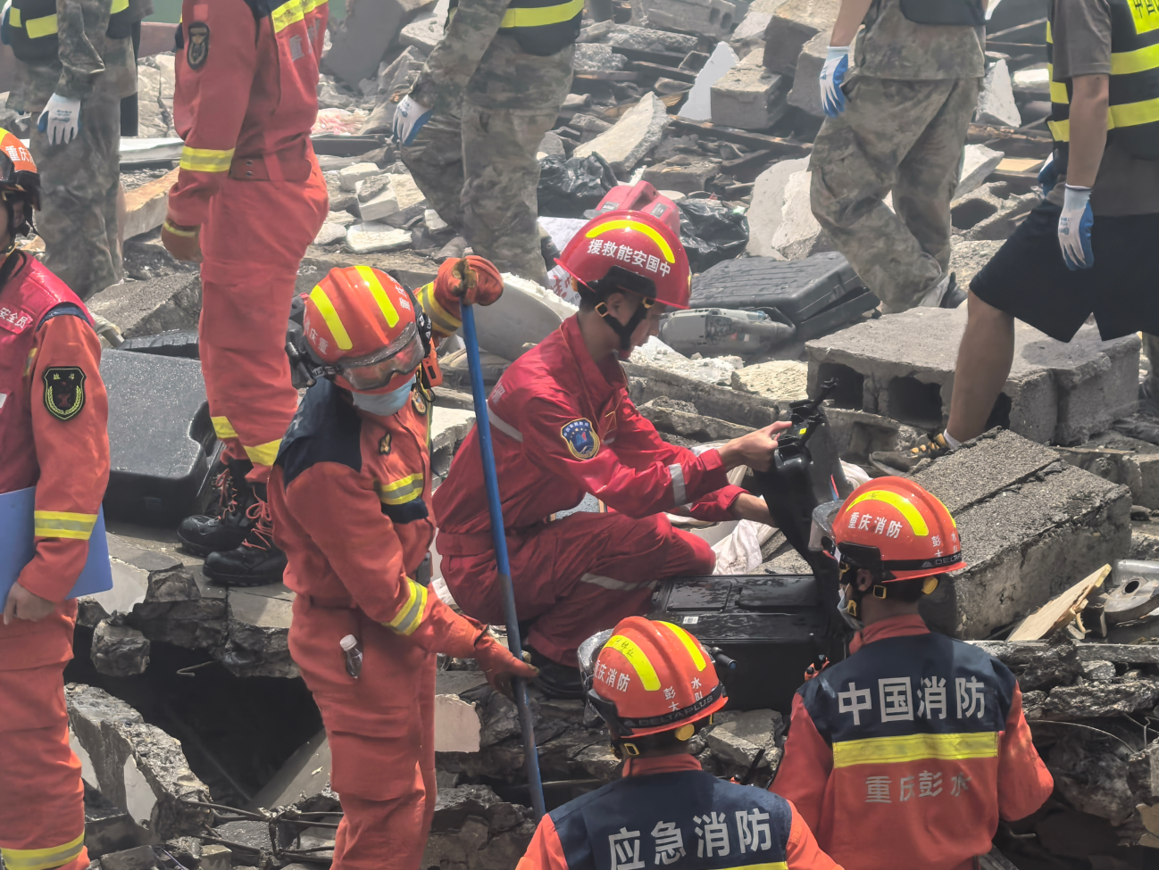 中国安能专业救援力量在崩塌核心区使用生命探测仪配合工程机械搜寻失联人员。
